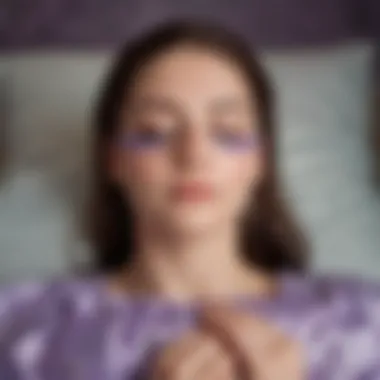 A person meditating with a silk lavender eye pillow